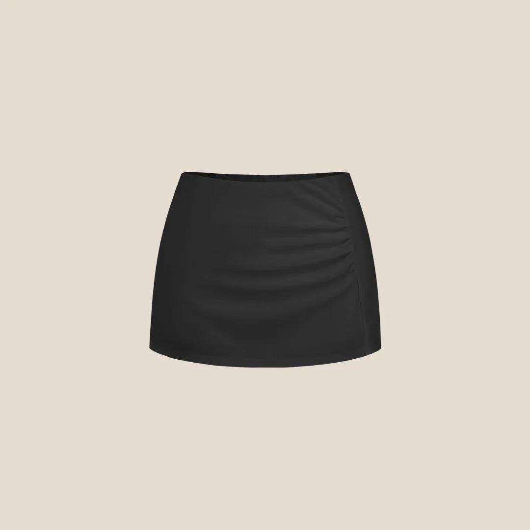 Olivia The Label black mini skirt, ruched detail, minimalist, on beige background